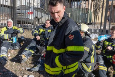 KYIV, UKRAINE - 25 Şubat 2022 Rusya 'nın Ukrayna' ya karşı savaşı. Kurtarma ekibi, Kyiv 'deki bir Rus roketi tarafından yok edilen bir evin yakınında çalışıyor.