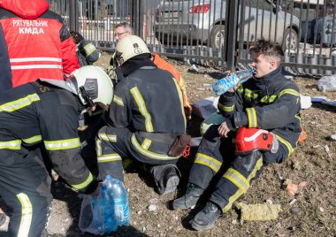 KYIV, UKRAINE - 25 Şubat 2022 Rusya 'nın Ukrayna' ya karşı savaşı. Kurtarma ekibi, Kyiv 'deki bir Rus roketi tarafından yok edilen bir evin yakınında çalışıyor.