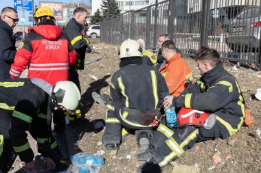 KYIV, UKRAINE - 25 Şubat 2022 Rusya 'nın Ukrayna' ya karşı savaşı. Kurtarma ekibi, Kyiv 'deki bir Rus roketi tarafından yok edilen bir evin yakınında çalışıyor.