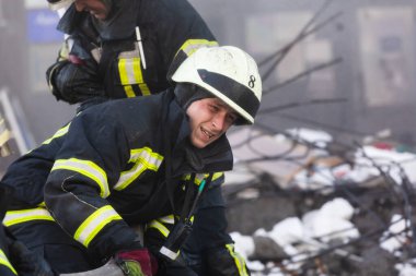KYIV, UKRAINE - 25 Şubat 2022 Rusya 'nın Ukrayna' ya karşı savaşı. Kurtarma ekibi, Kyiv 'deki bir Rus roketi tarafından yok edilen bir evin yakınında çalışıyor.