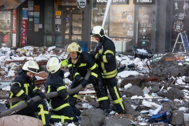 KYIV, UKRAINE - 25 Şubat 2022 Rusya 'nın Ukrayna' ya karşı savaşı. Kurtarma ekibi, Kyiv 'deki bir Rus roketi tarafından yok edilen bir evin yakınında çalışıyor.