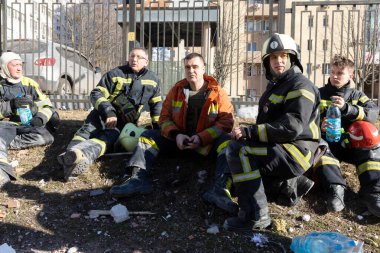 KYIV, UKRAINE - 25 Şubat 2022 Rusya 'nın Ukrayna' ya karşı savaşı. Kurtarma ekibi, Kyiv 'deki bir Rus roketi tarafından yok edilen bir evin yakınında çalışıyor.