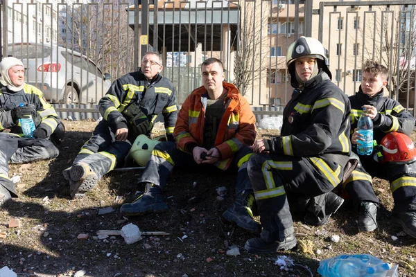 KYIV, UKRAINE - 25 Şubat 2022 Rusya 'nın Ukrayna' ya karşı savaşı. Kurtarma ekibi, Kyiv 'deki bir Rus roketi tarafından yok edilen bir evin yakınında çalışıyor.