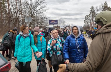 KYIV, UKRAINE - Mar. 05, 2022: Rusya 'nın Ukrayna' ya karşı savaşı. Irpen kasabasından tahliye edilen kadınlar, yaşlılar ve çocuklar Kyiv savunma taburu tarafından Kyiv 'e nakledildi. Ukrayna 'daki savaş mültecileri