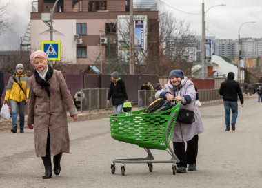 KYIV, UKRAINE - Mar. 05, 2022: Rusya 'nın Ukrayna' ya karşı savaşı. Irpen kasabasından tahliye edilen kadınlar, yaşlılar ve çocuklar Kyiv savunma taburu tarafından Kyiv 'e nakledildi. Ukrayna 'daki savaş mültecileri