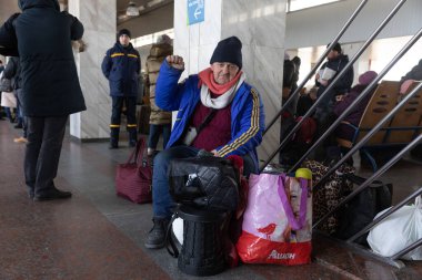KYIV, UKRAINE - Mar. 11, 2022: Ukrayna 'da savaş mültecileri. Kyiv tren istasyonundaki insanlar ülkenin batı güvenli bölgelerine tahliye edildi. İstasyonda yaşlı bir adam treni bekliyor.