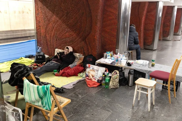 Kyiv Ukraine 2022年3月13日 ウクライナで戦争 爆弾避難所の地下鉄駅パレスウクライナでの生活 仮設ベッドの若い男が携帯電話でニュースを読む — ストック写真