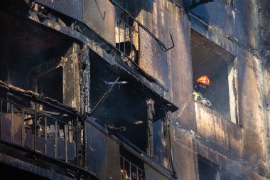 KYIV, UKRAINE - Mar. 15, 2022: Ukrayna 'da savaş. Rus bombasının vurduğu bir binada itfaiyeciler yangınla mücadele ediyor..