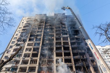 KYIV, UKRAINE - Mar. 15, 2022: Ukrayna 'da savaş. Rus bombasının vurduğu bir binada itfaiyeciler yangınla mücadele ediyor..