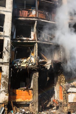 KYIV, UKRAINE - Mar. 15, 2022: Ukrayna 'da savaş. Rus bombasının vurduğu yangından kaynaklanan dumandaki ağır hasarlı yerleşim yerinin genel görüntüsü.