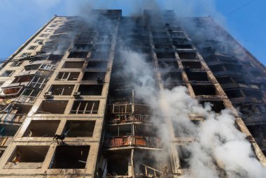 KYIV, UKRAINE - Mar. 15, 2022: Ukrayna 'da savaş. Rus bombasının vurduğu yangından kaynaklanan dumandaki ağır hasarlı yerleşim yerinin genel görüntüsü.