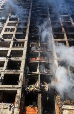 KYIV, UKRAINE - Mar. 15, 2022: Ukrayna 'da savaş. Rus bombasının vurduğu yangından kaynaklanan dumandaki ağır hasarlı yerleşim yerinin genel görüntüsü.