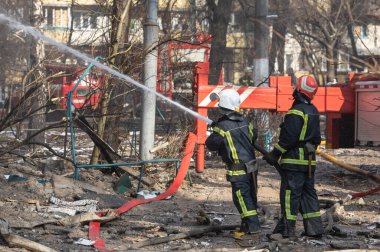 KYIV, UKRAINE - Mar. 15, 2022: Ukrayna 'da savaş. Rus bombasının vurduğu bir binada itfaiyeciler yangınla mücadele ediyor..