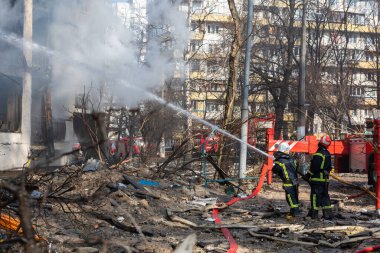 KYIV, UKRAINE - Mar. 15, 2022: Ukrayna 'da savaş. Rus bombasının vurduğu bir binada itfaiyeciler yangınla mücadele ediyor..