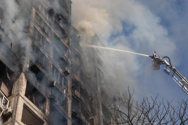 KYIV, UKRAINE - Mar. 15, 2022: Ukrayna 'da savaş. Rus bombasının vurduğu bir binada itfaiyeciler yangınla mücadele ediyor..