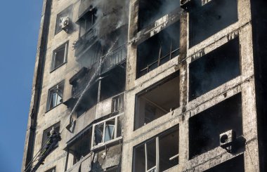 KYIV, UKRAINE - Mar. 15, 2022: Ukrayna 'da savaş. Rus bombasının vurduğu bir binada itfaiyeciler yangınla mücadele ediyor..