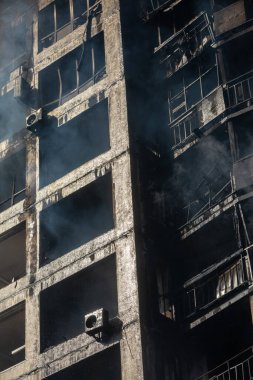 KYIV, UKRAINE - Mar. 15, 2022: Ukrayna 'da savaş. Rus bombasının vurduğu yangından kaynaklanan dumandaki ağır hasarlı yerleşim yerinin genel görüntüsü.