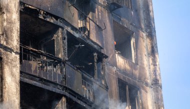 KYIV, UKRAINE - Mar. 15, 2022: Ukrayna 'da savaş. Rus bombasının vurduğu yangından kaynaklanan dumandaki ağır hasarlı yerleşim yerinin genel görüntüsü.