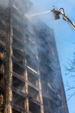 KYIV, UKRAINE - Mar. 15, 2022: Ukrayna 'da savaş. Rus bombasının vurduğu bir binada itfaiyeciler yangınla mücadele ediyor..