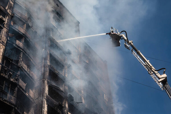 KYIV, UKRAINE - Mar. 15, 2022: War in Ukraine. Firefighters fighting a fire in a residential building that was hit by a Russian shell.