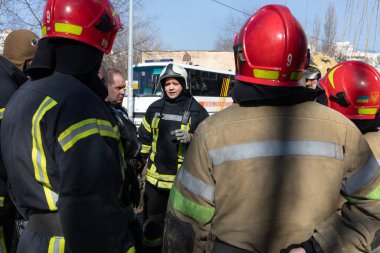 KYIV, UKRAINE - Mar. 15, 2022: Ukrayna 'da savaş. Kyiv sokaklarındaki itfaiyecilerden oluşan bir ekip her an kurbanlara yardım etmeye hazır. Görevi tamamladıktan sonra itfaiyeciler