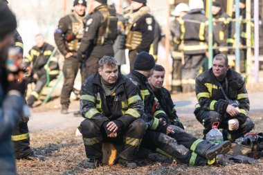 KYIV, UKRAINE - Mar. 15, 2022: Ukrayna 'da savaş. Kyiv sokaklarındaki itfaiyecilerden oluşan bir ekip her an kurbanlara yardım etmeye hazır. Görevi tamamladıktan sonra itfaiyeciler