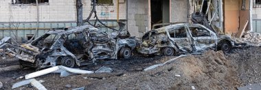 KYIV, UKRAINE - Mar. 20, 2022: Ukrayna 'da savaş. Patlayıcı huni, konut binası ve araçlar Rus roketinin Kyiv 'e yaptığı saldırıdan sonra enkaz düşmesi sonucu hasar gördü.