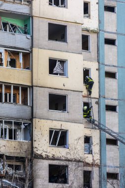 KYIV, UKRAINE - Mar. 20, 2022: Ukrayna 'da savaş. Rus roketinin Kyiv 'e yaptığı saldırı sonucu bina yıkıldı. Kurtarma ekipleri patlamadan sonra binanın durumunu inceliyor.