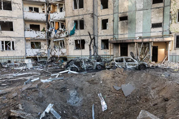 KYIV, UKRAINE - Mar. 20, 2022: Ukrayna 'da savaş. Patlayıcı huni, konut binası ve araçlar Rus roketinin Kyiv 'e yaptığı saldırıdan sonra enkaz düşmesi sonucu hasar gördü.