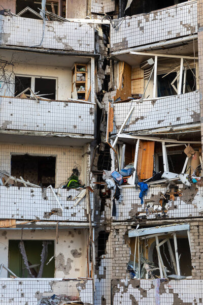 KYIV, UKRAINE - Mar. 20, 2022: War in Ukraine. Residential building and cars damaged by falling debris after Russian rocket attack on Kyiv
