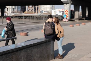 KYIV, UKRAINE - Mar. 25, 2022: Ukrayna 'da savaş. Aşk ve Savaş. Kyiv caddesinde öpüşen genç çift