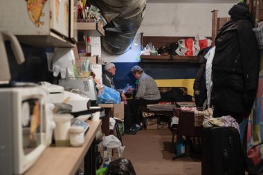 KYIV, UKRAINE - Mar. 28, 2022: Rusya 'nın Ukrayna' ya saldırısı Ukrayna 'nın başkenti Kyiv' de devam ederken, olası hava saldırılarından korunmak için bir sığınakta yemek yiyen çift. Rusya 'nın Ukrayna' ya karşı savaşı.