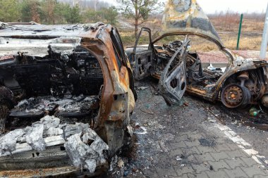 KYIV REG, UKRAINE - Nisan. 02, 2022: Kyiv-Zhytomyr karayolunda tahrip edilmiş ve yanmış bir araba görüldü..