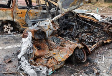 KYIV REG, UKRAINE - Nisan. 02, 2022: Kyiv-Zhytomyr karayolunda tahrip edilmiş ve yanmış bir araba görüldü..