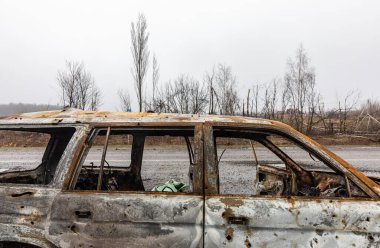 KYIV REG, UKRAINE - Nisan. 02, 2022: Kyiv-Zhytomyr karayolunda tahrip edilmiş ve yanmış bir araba görüldü..