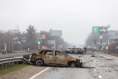 KYIV REG, UKRAINE - Nisan. 02, 2022: Kyiv-Zhytomyr karayolunda tahrip edilmiş ve yanmış bir araba görüldü..