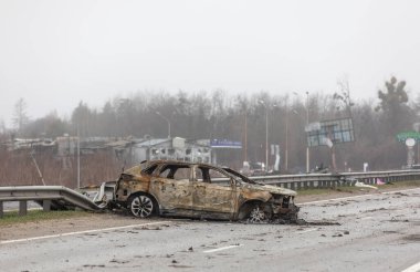 KYIV REG, UKRAINE - Nisan. 02, 2022: Kyiv-Zhytomyr karayolunda tahrip edilmiş ve yanmış bir araba görüldü..