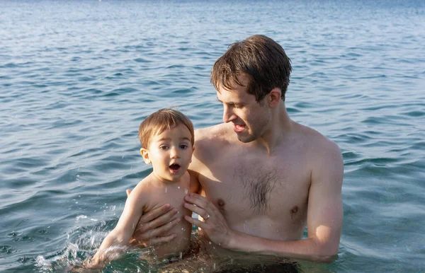 幸せな家族と健康的なライフスタイル 幼い父親が子供に海で泳ぐことを教える — ストック写真