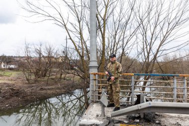 IRPIN, UKRAINE - Nisan. 10, 2022: Ukraynalı askerler yeniden ele geçirilen Irpin şehrinin dışındaki yıkılmış bir köprünün yakınında görevdeler.