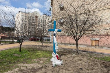 BuCHA, UKRAINE - Nisan. 12, 2022: Ukrayna 'nın Kyiv kenti yakınlarındaki Bucha şehri tarafından ele geçirilen apartman bloklarının yanındaki cesetlerle birlikte mezarlar.