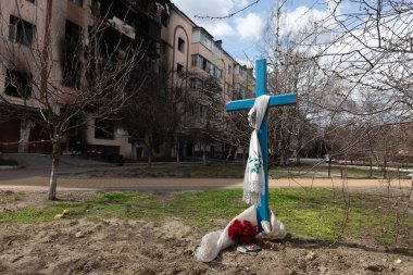 BuCHA, UKRAINE - Nisan. 12, 2022: Ukrayna 'nın Kyiv kenti yakınlarındaki Bucha şehri tarafından ele geçirilen apartman bloklarının yanındaki cesetlerle birlikte mezarlar.