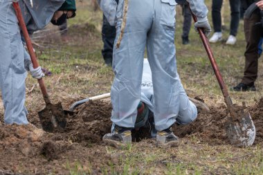 BUCHA, UKRAINE - Apr. 12, 2022: Genocide in Bucha. Forensic police officers exhume bodies in Bucha, outskirts of Kyiv, Ukraine. clipart