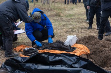BuCHA, UKRAINE - Nisan. 12, 2022: Bucha 'da soykırım. Adli polis memurları Bucha, Ukrayna, Kyiv 'in varoşlarında cesetleri mezardan çıkardılar..
