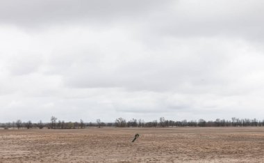 CHERNIHIV Reg., UKRAINE - Nisan. 18, 2022: Chernihiv yakınlarındaki bir alanın ortasında patlamamış bir roket mermisi. 