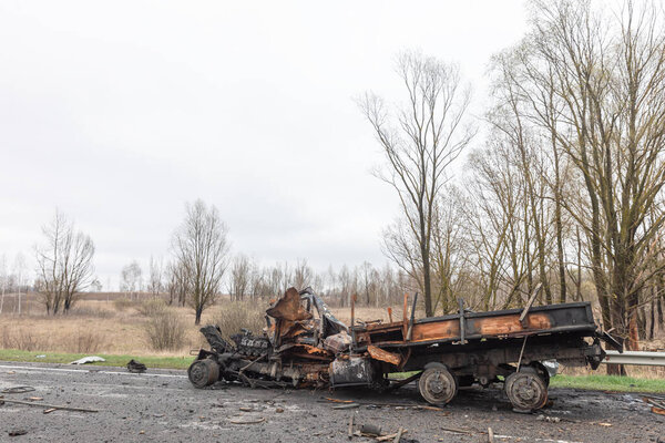War in Ukraine. Burnt out cars on the edge of the road. Traces of the Russian army invasion of Ukraine on the highway near Chernihiv.