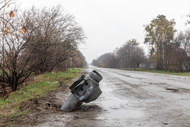 HOSTOMIL Reg, UKRAINE - Nisan. 22, 2022: Rus işgal birliklerinin patlamamış roketi yoldan çekiliyor.
