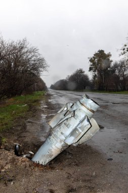 HOSTOMIL Reg, UKRAINE - Nisan. 22, 2022: Rus işgal birliklerinin patlamamış roketi yoldan çekiliyor.