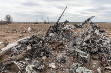 MAKARIV, UKRAINE - Nisan. 23, 2022: Makariv köyü yakınlarındaki bir tarlanın ortasında düşmüş ve yanmış bir helikopterin enkazı arasında ölen Rus askeri pilotların iskeletleri