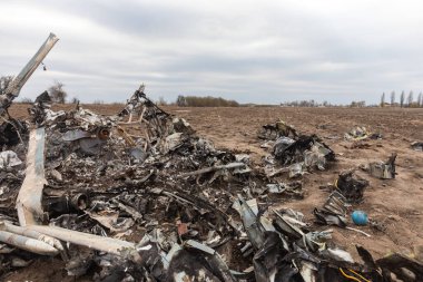 MAKARIV, UKRAINE - Nisan. 23, 2022: Makariv köyü yakınlarındaki bir tarlanın ortasında düşen ve yanmış bir askeri helikopterin enkazı