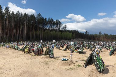 IRPIN, UKRAINE - Mayıs. 01, 2022: Irpin 'deki mezarlıkta çok sayıda taze mezar. İnsanlar sevdiklerini mezarlıkta anarlar.